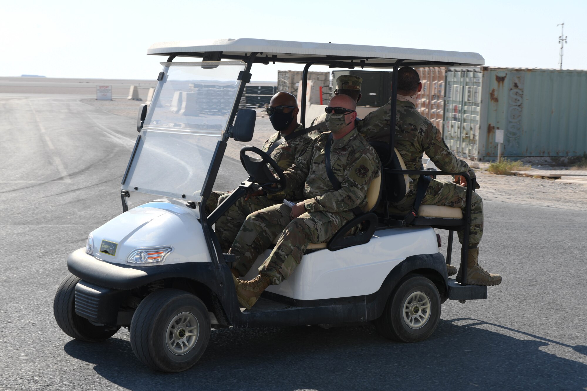 Senior Master Sgt. Richard Miller, the aerial port superintendent at Al Udeid Air Base, Qatar, drives the 379th Air Expeditionary Wing Command Chief, Chief Master Sgt. Kenneth Bruce in a golf cart during a tour of the facilities used by the 8th Expeditionary Air Mobility Squadron on Oct. 23, 2020. The Airmen of The Mighty Ocho are responsible for transporting an average of 10 million pounds of cargo and 5 thousand passengers throughout the U.S. Central Command area of responsibility each month, accounting for more than 36 percent of airlift operations in Europe and Southwest Asia. (U.S. Air Force photo by Staff Sgt. Kayla White)