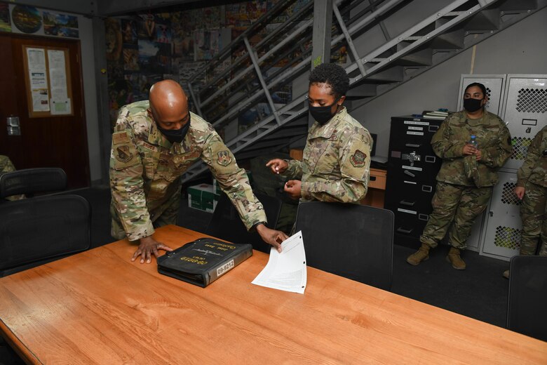 U.S. Air Force Staff Sgt. Shanita Davies. assigned to the 8th Expeditionary Air Mobility Squadron at Al Udeid Air Base, Qatar, guides the 379th Air Expeditionary Wing Command Chief, Chief Master Sgt. Kenneth Bruce, through her section of the 8th EAMS work center on Oct. 23, 2020. The Airmen of The Mighty Ocho are responsible for transporting an average of 10 million pounds of cargo and 5 thousand passengers throughout the U.S. Central Command area of responsibility each month, accounting for more than 36 percent of airlift operations in Europe and Southwest Asia. (U.S. Air Force photo by Staff Sgt. Kayla White)