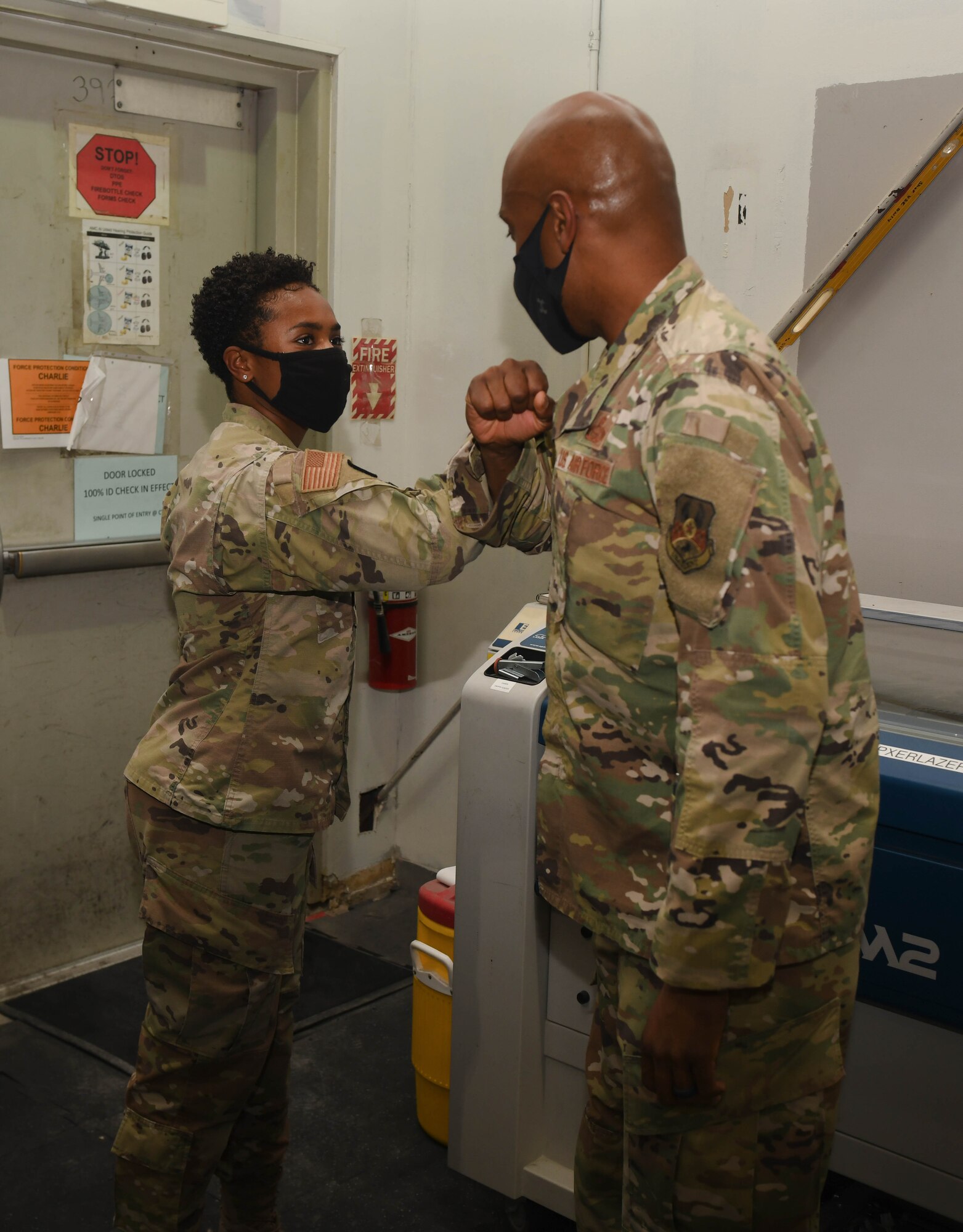 U.S. Air Force Staff Sgt. Shanita Davies. assigned to the 8th Expeditionary Air Mobility Squadron at Al Udeid Air Base, Qatar, elbow bumps the 379th Air Expeditionary Wing Command Chief, Chief Master Sgt. Kenneth Bruce, on Oct. 23, 2020, after receiving one of his coins for her outstanding performance during her deployment. The Airmen of The Mighty Ocho are responsible for transporting an average of 10 million pounds of cargo and 5 thousand passengers throughout the U.S. Central Command area of responsibility each month, accounting for more than 36 percent of airlift operations in Europe and Southwest Asia. (U.S. Air Force photo by Staff Sgt. Kayla White