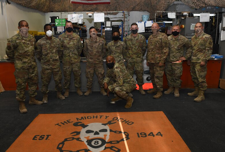 Members of the 8th Expeditionary Air Mobility Squadron at Al Udeid Air Base, Qatar, pose for a group photo with the 379th Air Expeditionary Wing Command Chief, Chief Master Sgt. Kenneth Bruce on Oct. 23, 2020. The Airmen of the 8th EAMS, also known as The Airmen of The Mighty Ocho are responsible for transporting an average of 10 million pounds of cargo and 5 thousand passengers throughout the U.S. Central Command area of responsibility each month, accounting for more than 36 percent of airlift operations in Europe and Southwest Asia. (U.S. Air Force photo by Staff Sgt. Kayla White)