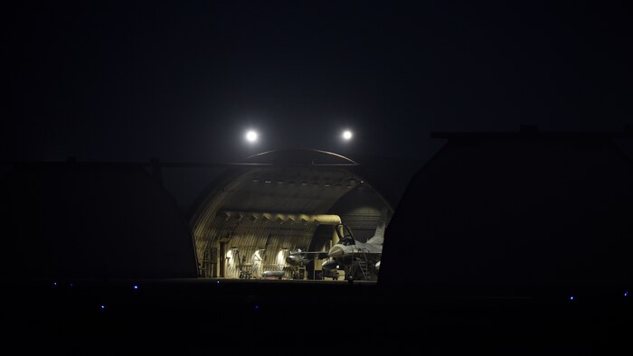 A fighter jet in a hardened aircraft shelter.