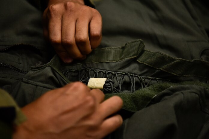 A photo of an Airman inspecting an anti-gravity suit.