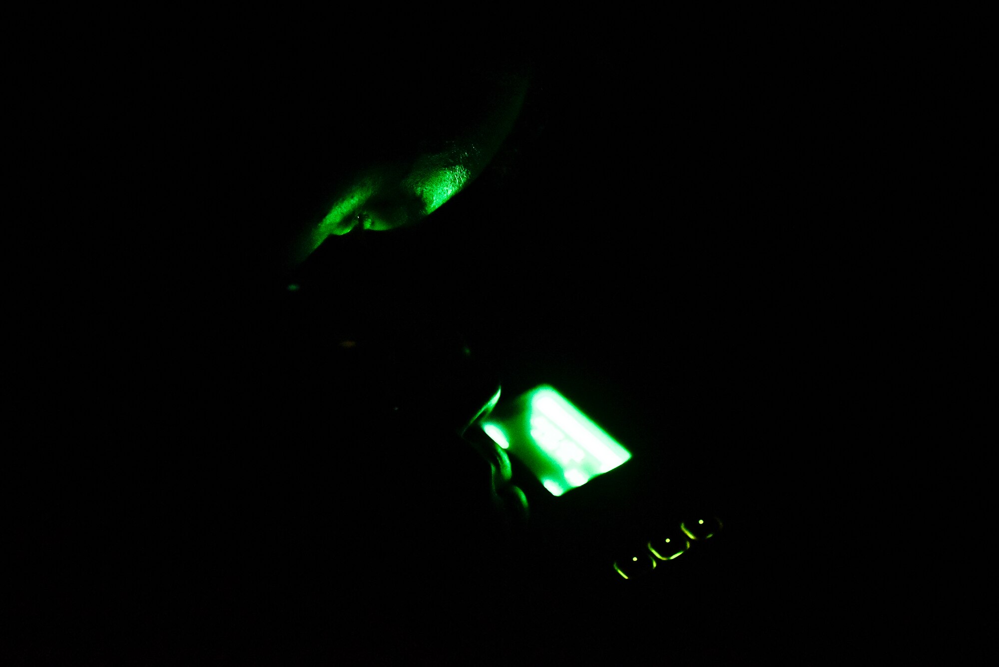 An Airman inspecting night vision goggles.