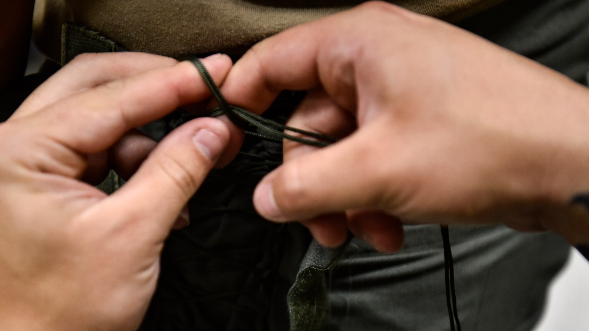 An Airman tightening an anti-gravity suit.
