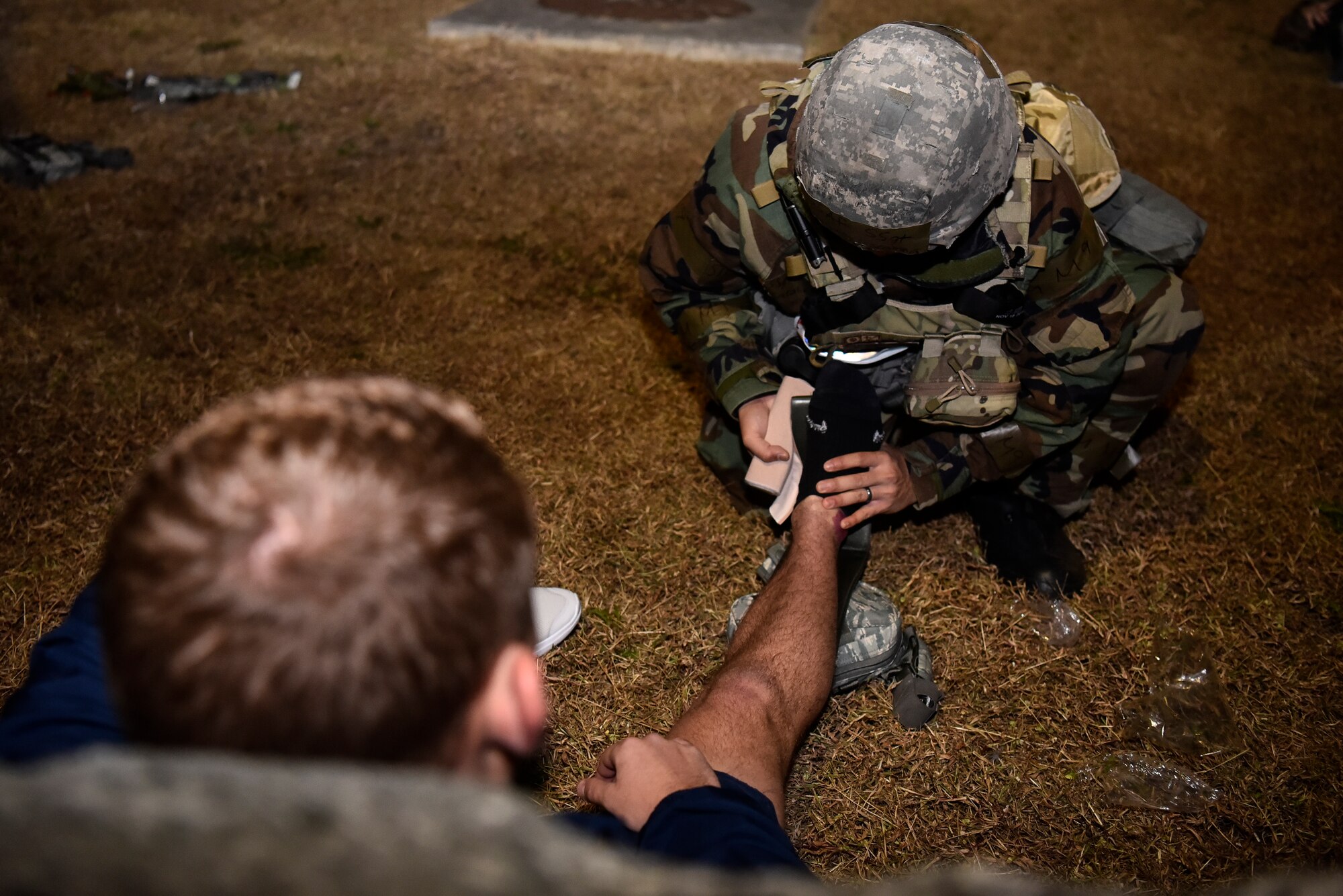 An Airmen assessing a simulated victim.