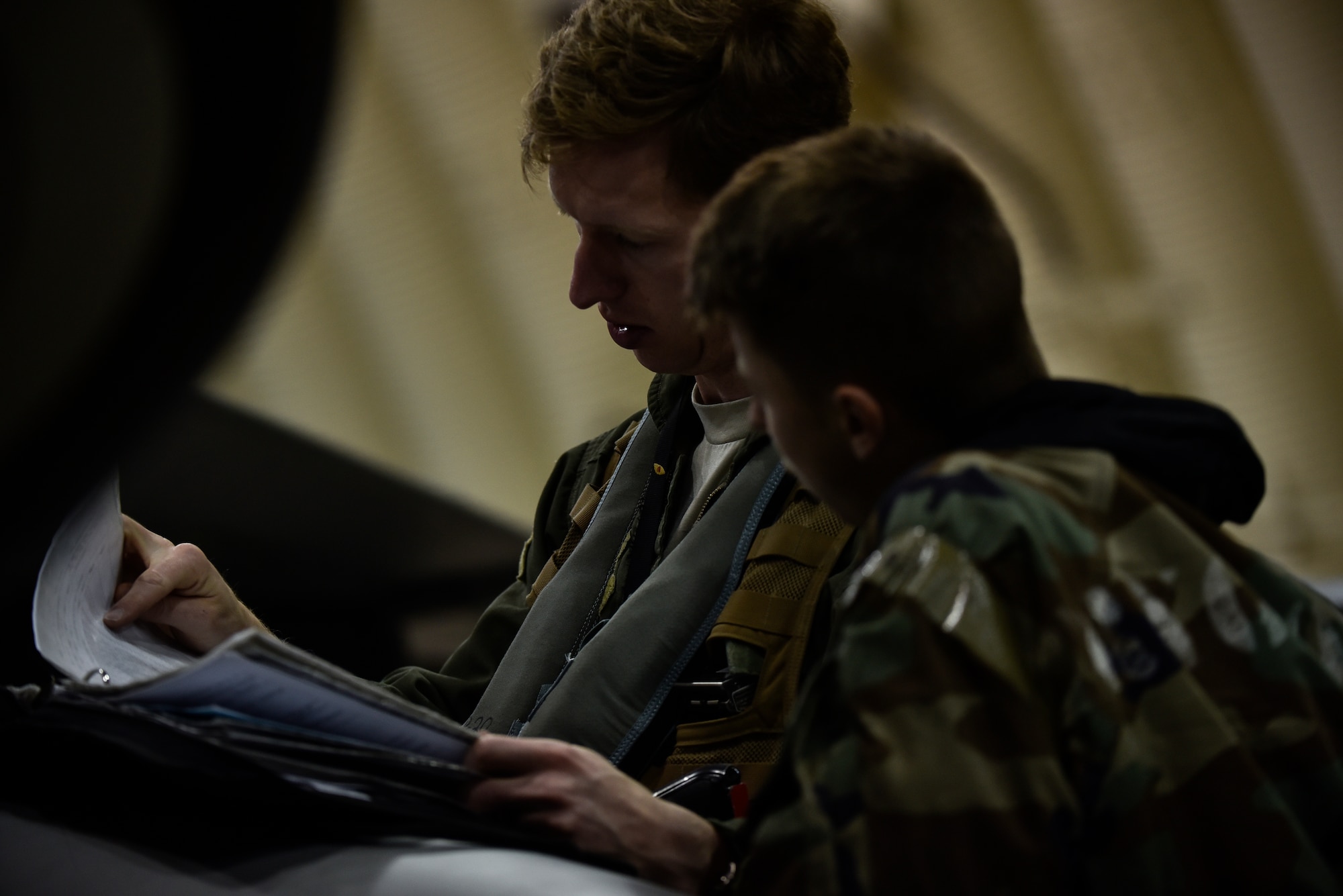 A crew chief and pilot reviewing a checklist.