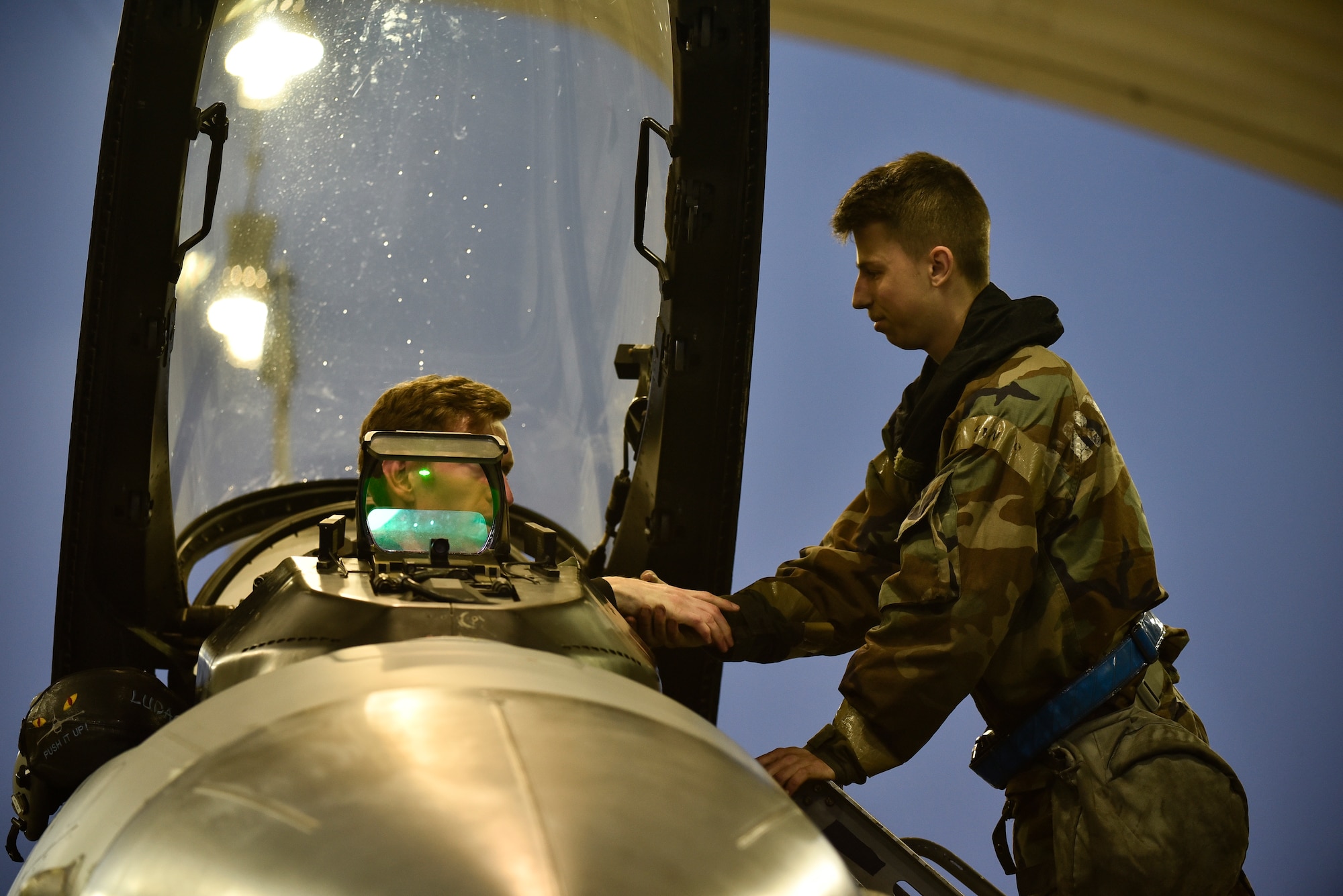 A crew chief and pilot shaking hands before flight.