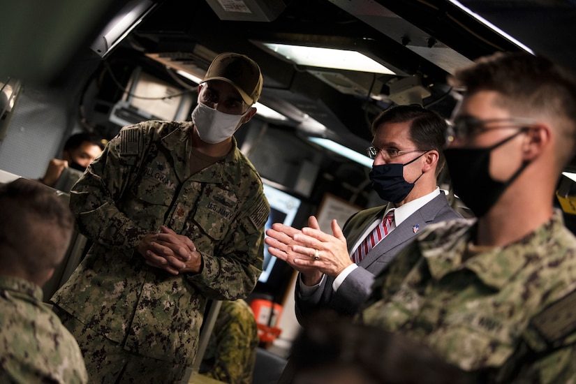 Defense Secretary Dr. Mark T. Esper speaks with service members on board a ship.
