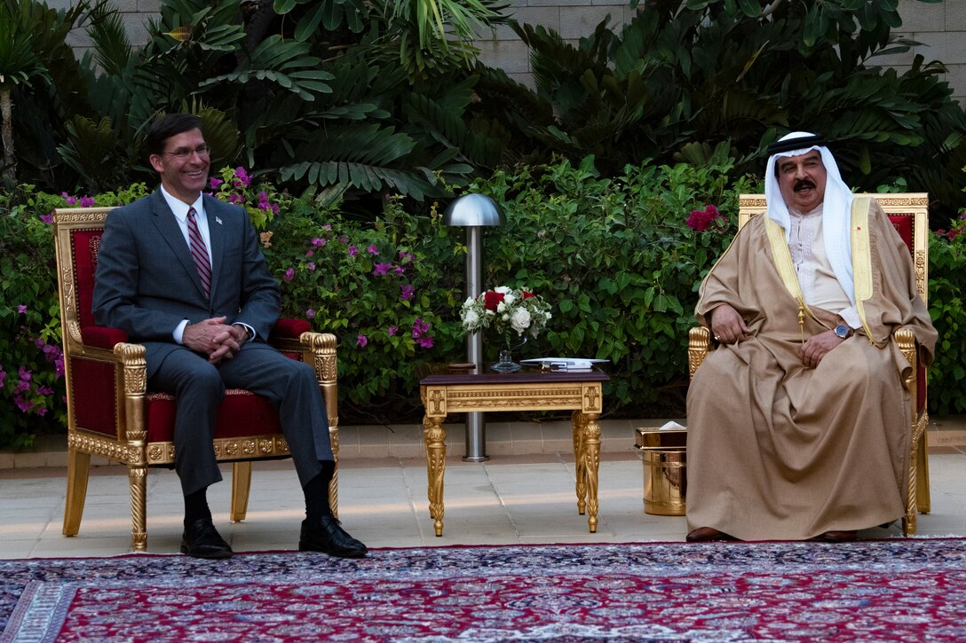 Two men sit in chairs next to each other.