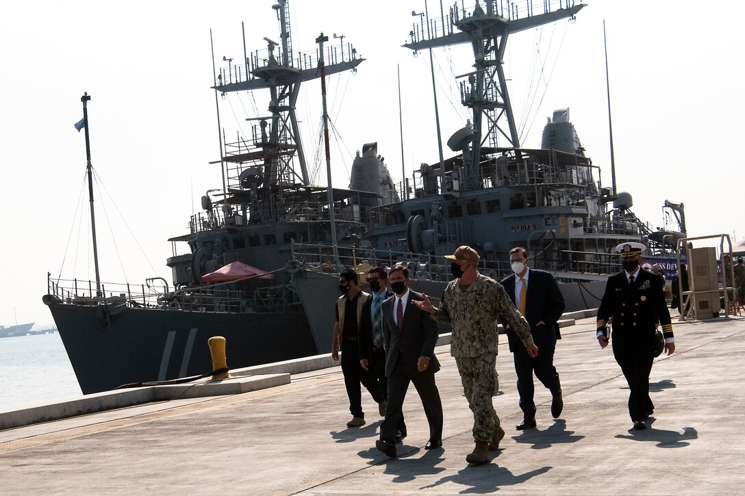 Defense Secretary Dr. Mark T. Esper walks with a group of people.