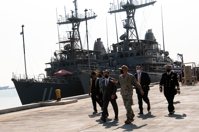 Defense Secretary Dr. Mark T. Esper walks with a group of people.