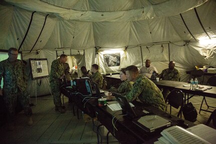 Sailors with Naval Beach Group-2 update computer models and maintain communication with their brethren at Marine Corps Support Facility-Blount Island from a Tactical Operations Center aboard Naval Station Mayport, Jacksonville, Fla., Aug. 11, 2015. The TOC ensured Marines with Combat Logistics Regiment-25 and sailors with NBG-2 were always on the same page and that operations during the Marine Prepositioning Force Exercise ran smoothly. (U.S. Marine Corps photo by Sgt. Shawn Valosin/Released)