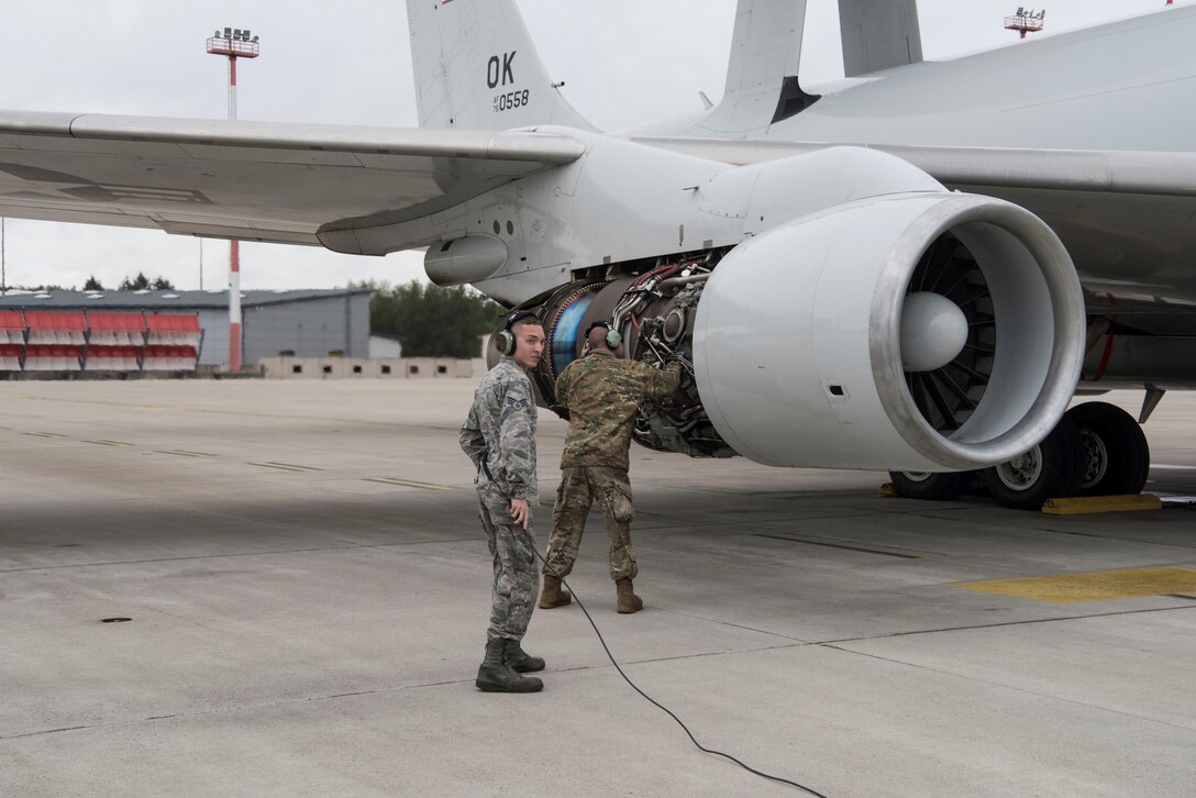 photo of two airman in front of a plane