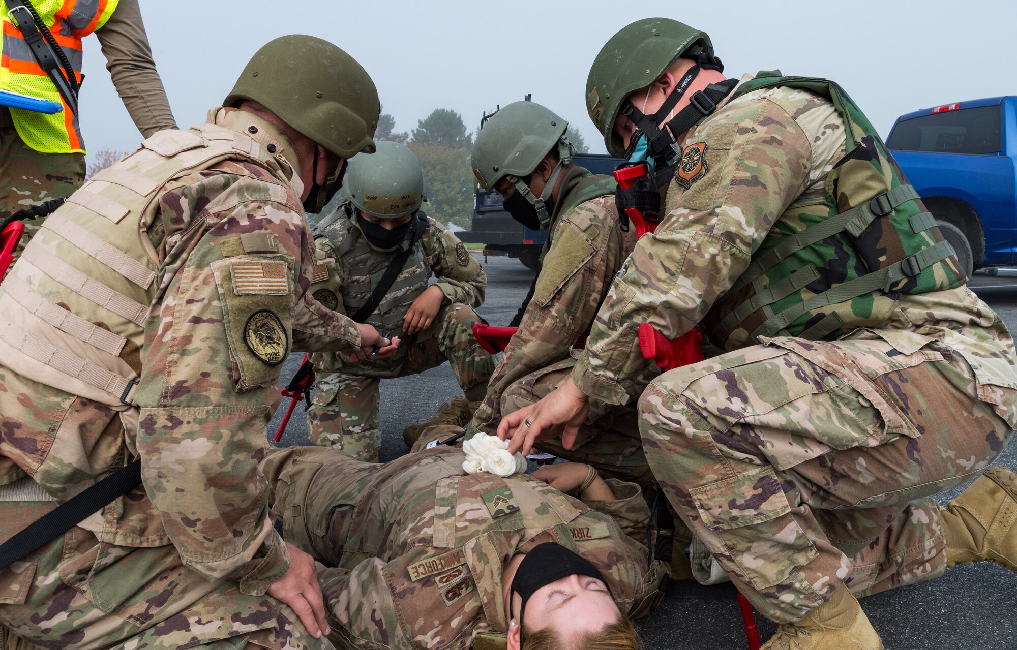 Four 436th Civil Engineer Squadron Prime Base Engineer Emergency Force members perform simulated self-aid and buddy care to Senior Airman Rachel Zirkle, 436th CES explosive ordnance disposal journeyman, Oct. 21, 2020, on Dover Air Force Base, Delaware. Sixty-four Prime BEEF members made up 10 teams in a 96-hour readiness exercise that included SABC, vehicle convoy techniques and land navigation exercises prior to arriving at the Tactics and Leadership Nexus. While at the TALN, they participated in night vision goggle familiarization; chemical, biological and radiological and nuclear defense training; individual movement techniques; and defense fighting position exercises. (U.S. Air Force photo by Roland Balik)