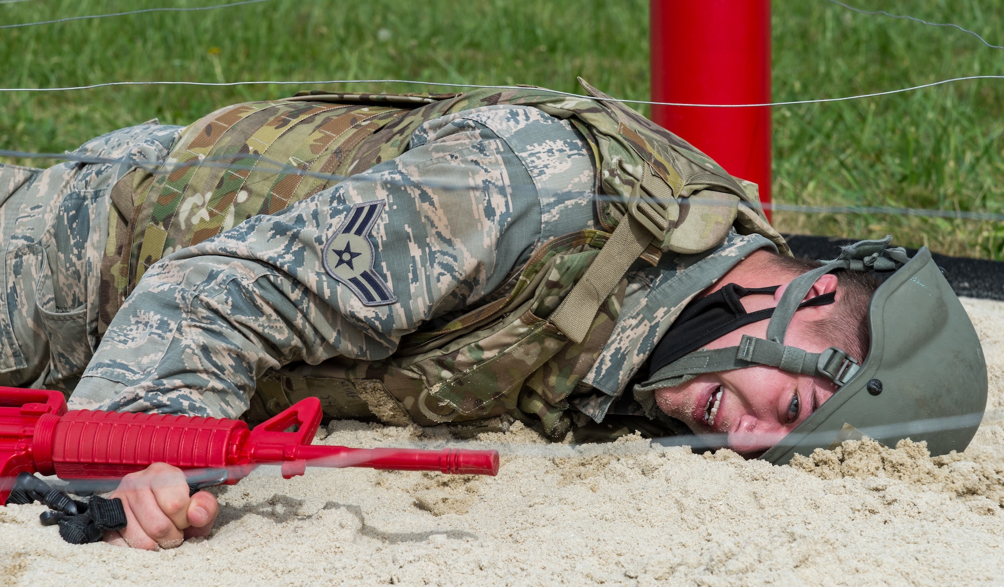 Airman 1st Class Skylar Cunningham, 436th Civil Engineer Squadron Prime Base Engineer Emergency Force member, performs a low crawl during an obstacle course exercise Oct. 21, 2020, at Tactics and Leadership Nexus on Dover Air Force Base, Delaware. Sixty-four Prime BEEF members made up 10 teams that participated in a 96-hour readiness exercise that included self-aid and buddy care, vehicle convoy techniques and land navigation prior to arriving at the TALN. While at TALN, they participated in night vision goggle familiarization; chemical, biological and radiological and nuclear defense training; individual movement techniques; and defense fighting position exercises. (U.S. Air Force photo by Roland Balik)