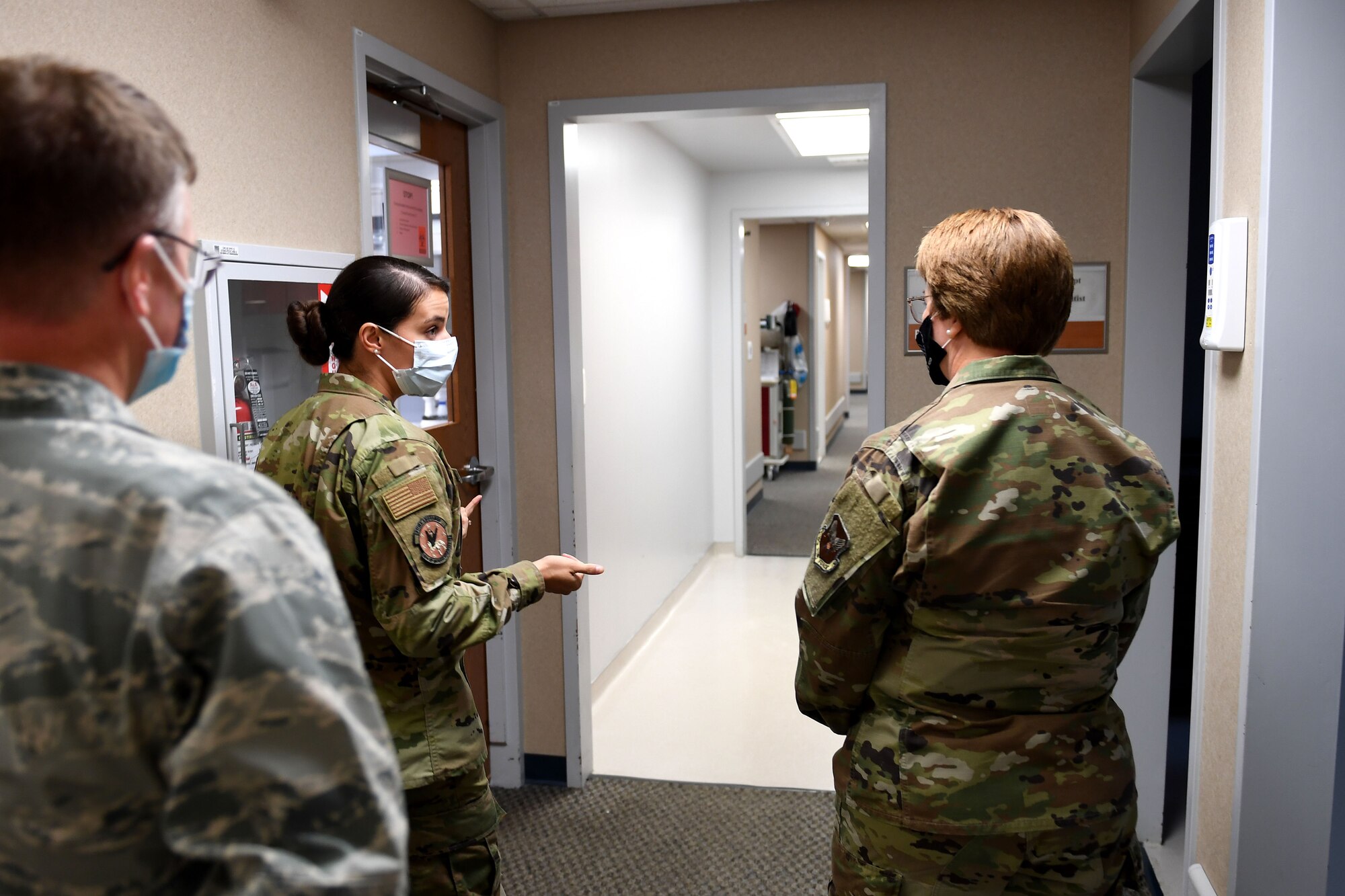 Airmen walk down a hall.