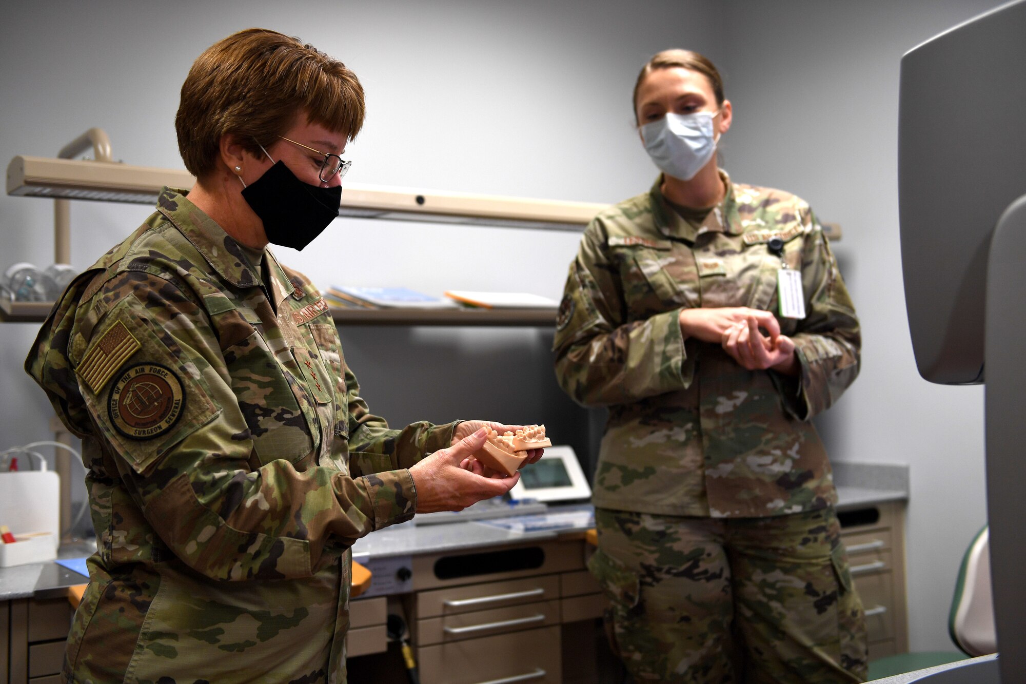 Airman holds fake mouth.