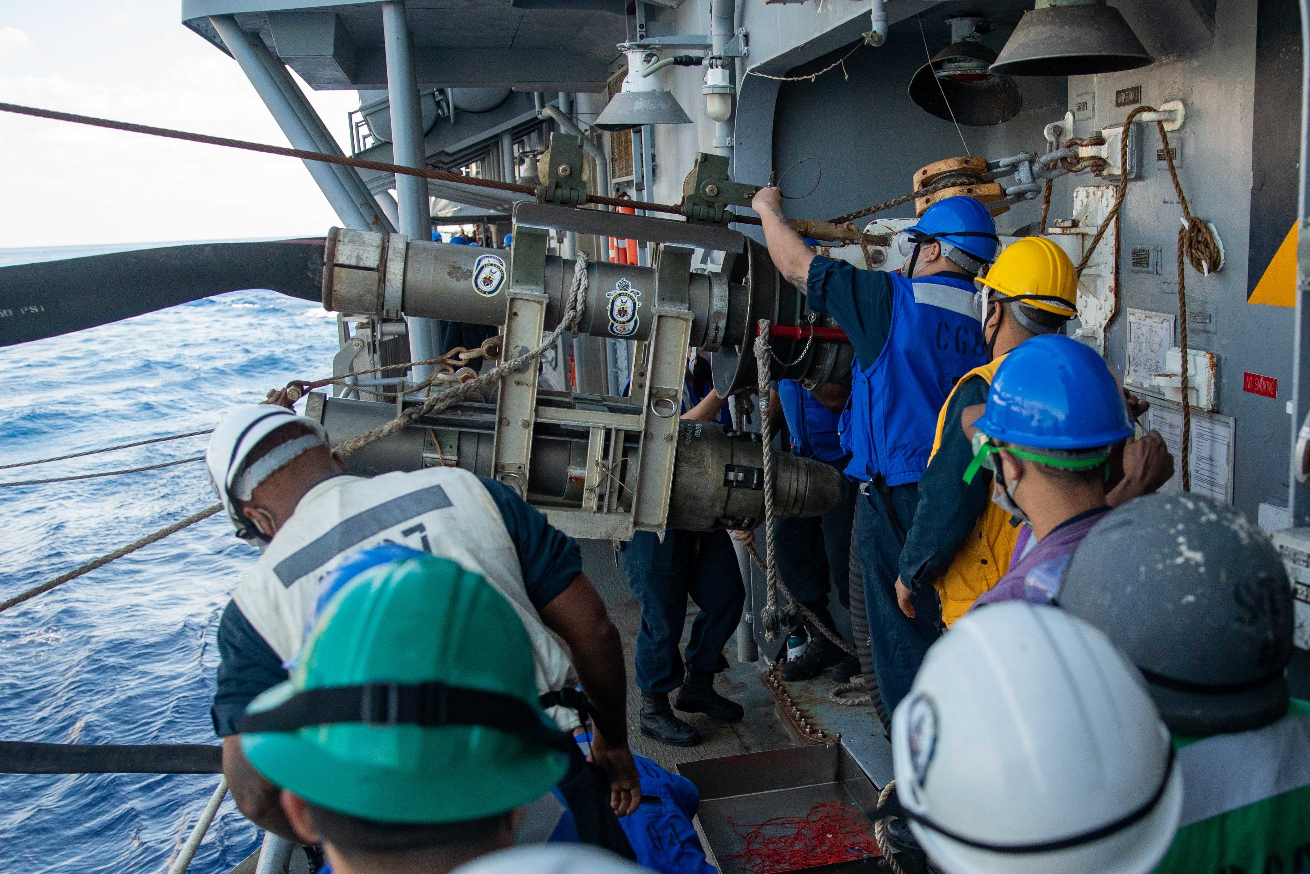 Sailors secure a fuel probe to the bell mouth of the Ticonderoga-class guided missile cruiser USS Shiloh (CG 67) during a replenishment-at-sea with the fleet replenishment oiler USNS Tippecanoe (T-AO 199) during Keen Sword 21.
