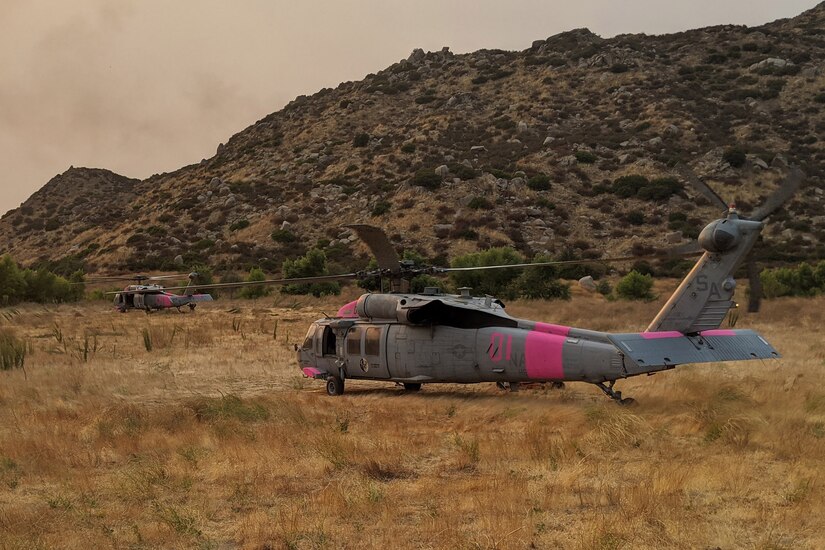 Two helicopters sit on the ground.