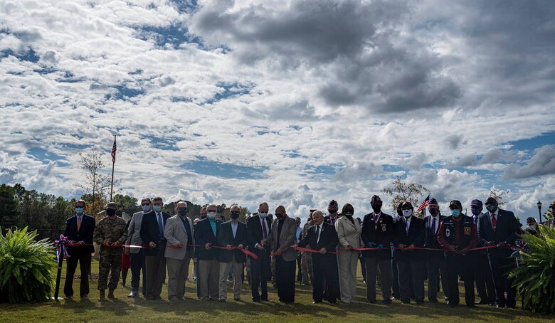 A group of people gather to cut a ribbon.