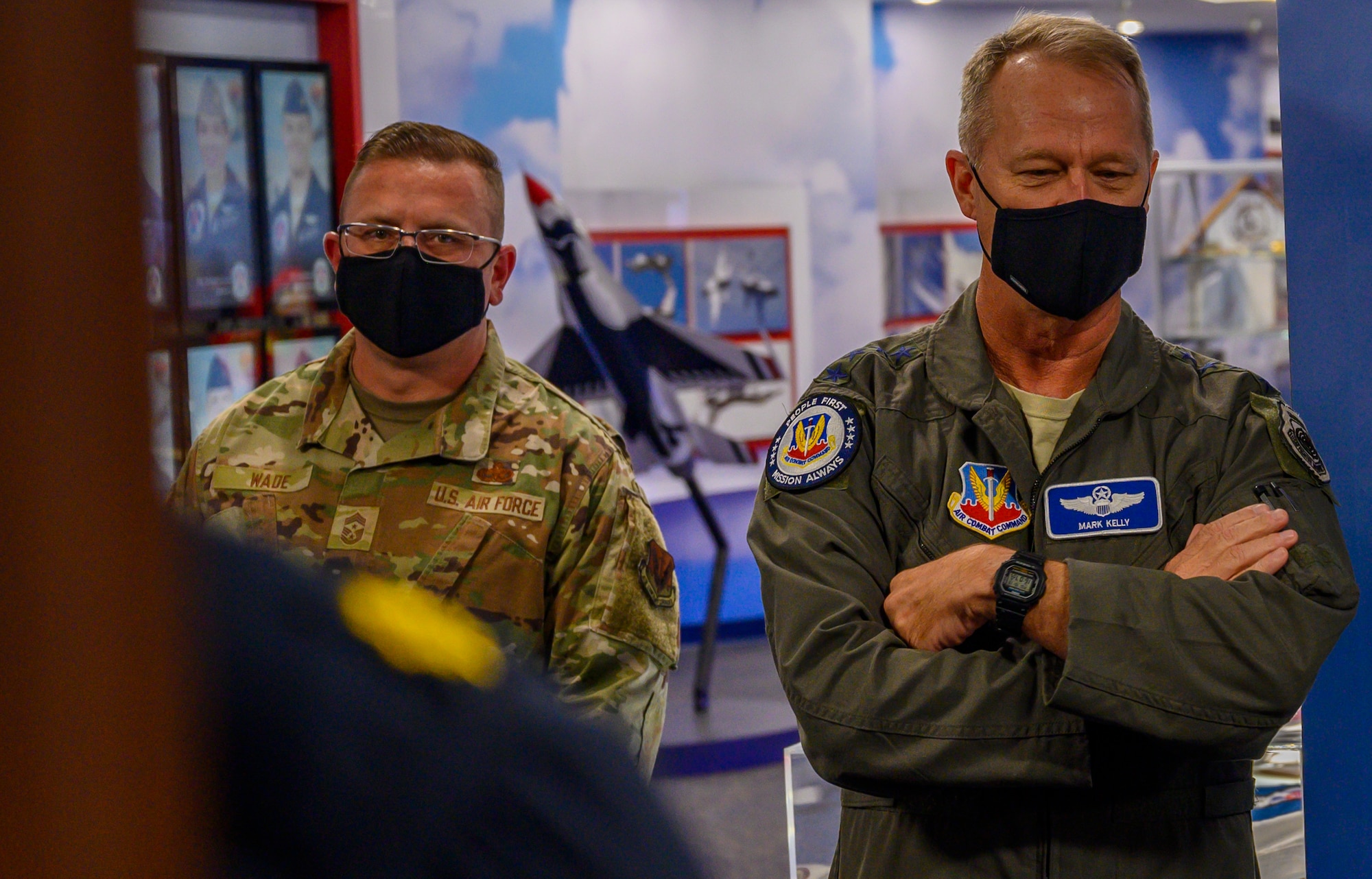 Airmen stand in a hallway.