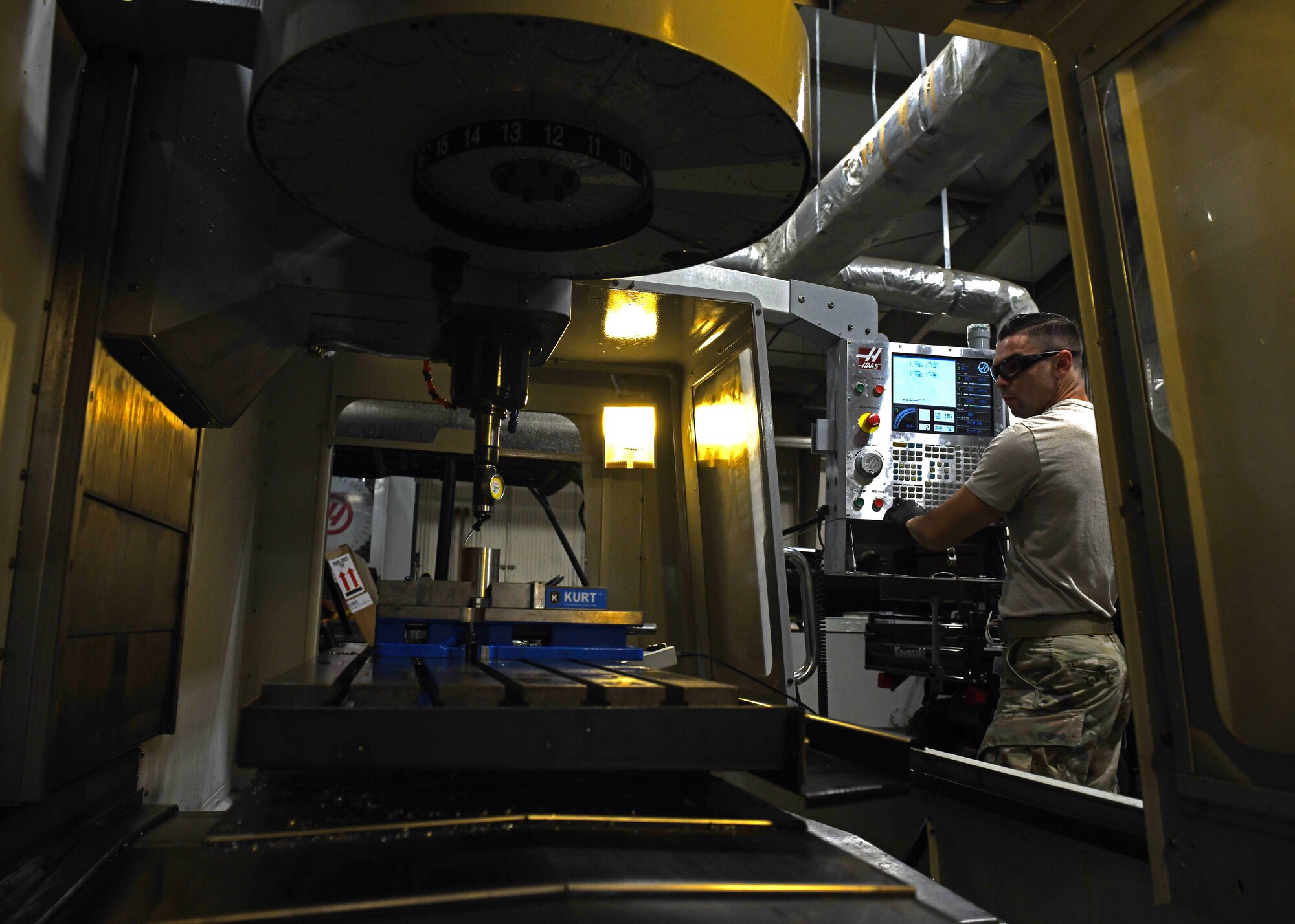 Staff Sgt. Tim Bergin, a 33rd Maintenance Squadron Fabrication Flight metals technician shift lead, employs computerized controls during a metals job Oct. 7, 2020, at Eglin Air Force Base, Florida. The machine uses rotating multi-point tools to progressively remove material from the workpiece and produce a custom-designed part or product. (U.S. Air Force photo by Senior Airman Amber Litteral)