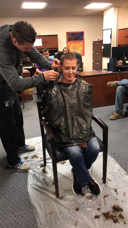Photo of Airman getting her head shaved