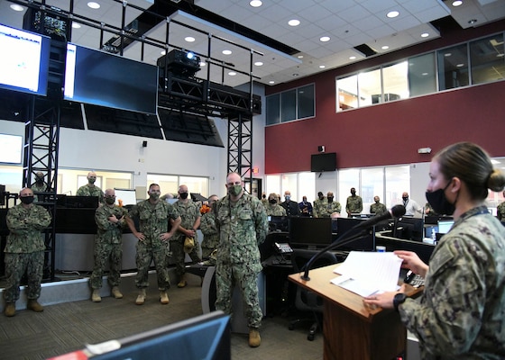 Chief of Naval Operations (CNO) Adm. Mike Gilday listens to a command brief from Cryptologic Technician Networks 1st Class Veronica Steinhaus while touring the Naval Network Warfare Command (NNWC) and Navy Cyber Defense Operations Command (NCDOC) watch floor. (U.S. Navy photo by Robert Fluegel/RELEASED)