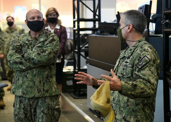 Chief of Naval Operations (CNO) Adm. Mike Gilday receives a brief from Commander Naval Information Forces, Vice Adm. Brian Brown while touring the Naval Network Warfare Command (NNWC) and Navy Cyber Defense Operations Command (NCDOC) watch floor. (U.S. Navy photo by Robert Fluegel/RELEASED)
