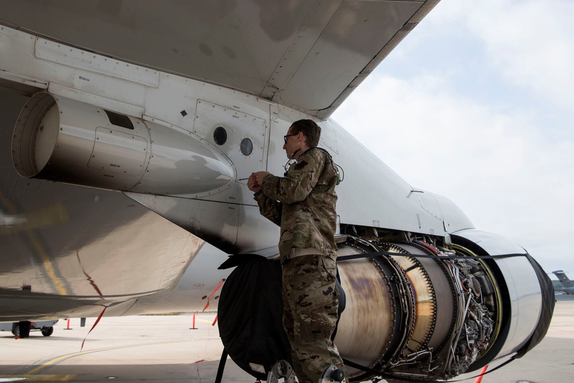 photo of Airman working on plane on flightline