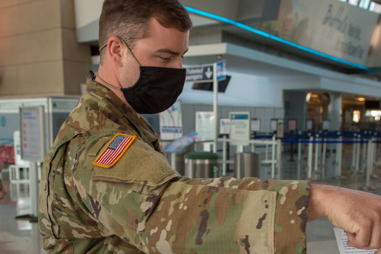 A service member puts a form into a box.