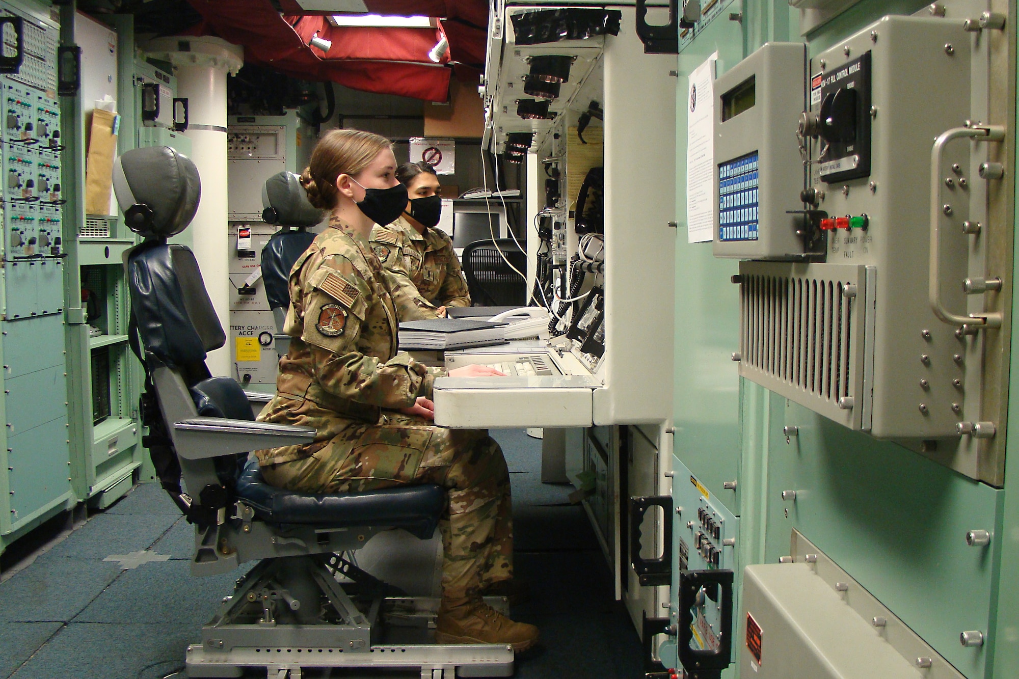 Missileers sit in a launch control center.