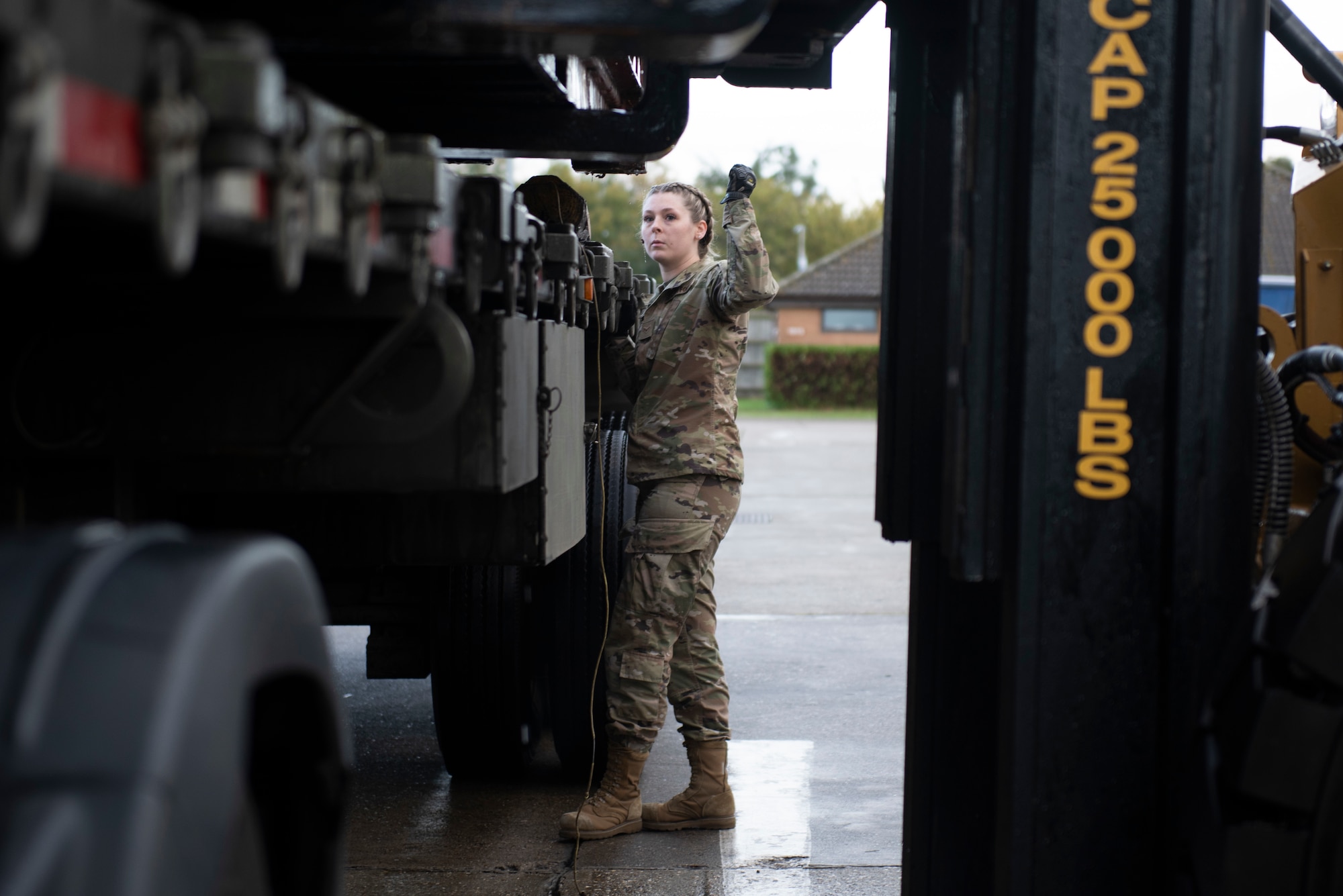 U.S. Air Force Airman 1st Class Kylie Gallivan, 48th Logistics Readiness Squadron ground transportation specialist, oversees the loading of heavy cargo at Royal Air Force Lakenheath, England, Oct 15, 2020. Ground transportation specialists must accumulate dozens of hours of driving experience to qualify on their vehicles. (U.S. Air Force photo by Airman 1st Class Anthony Clingerman)