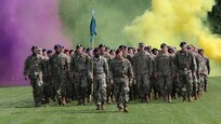 Soldier-students enter the field amid colored smoke during the 7th Army NCO Academy graduation ceremony in Grafenwoehr, Germany, June 15, 2018.