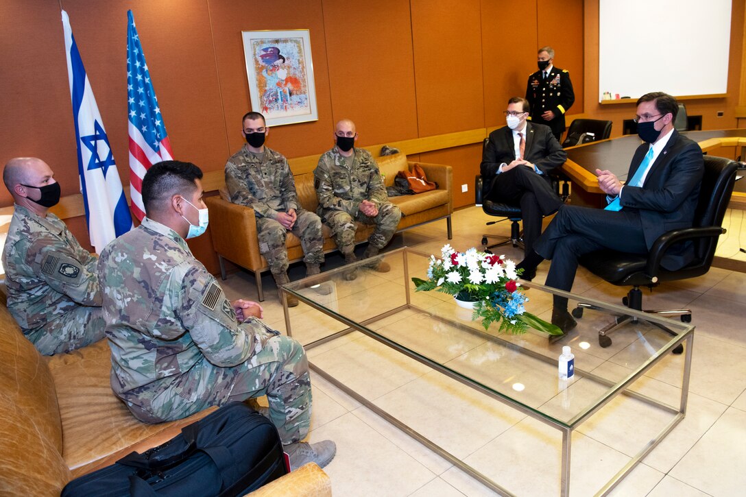 Soldiers sit around a coffee table with Defense Department leaders.