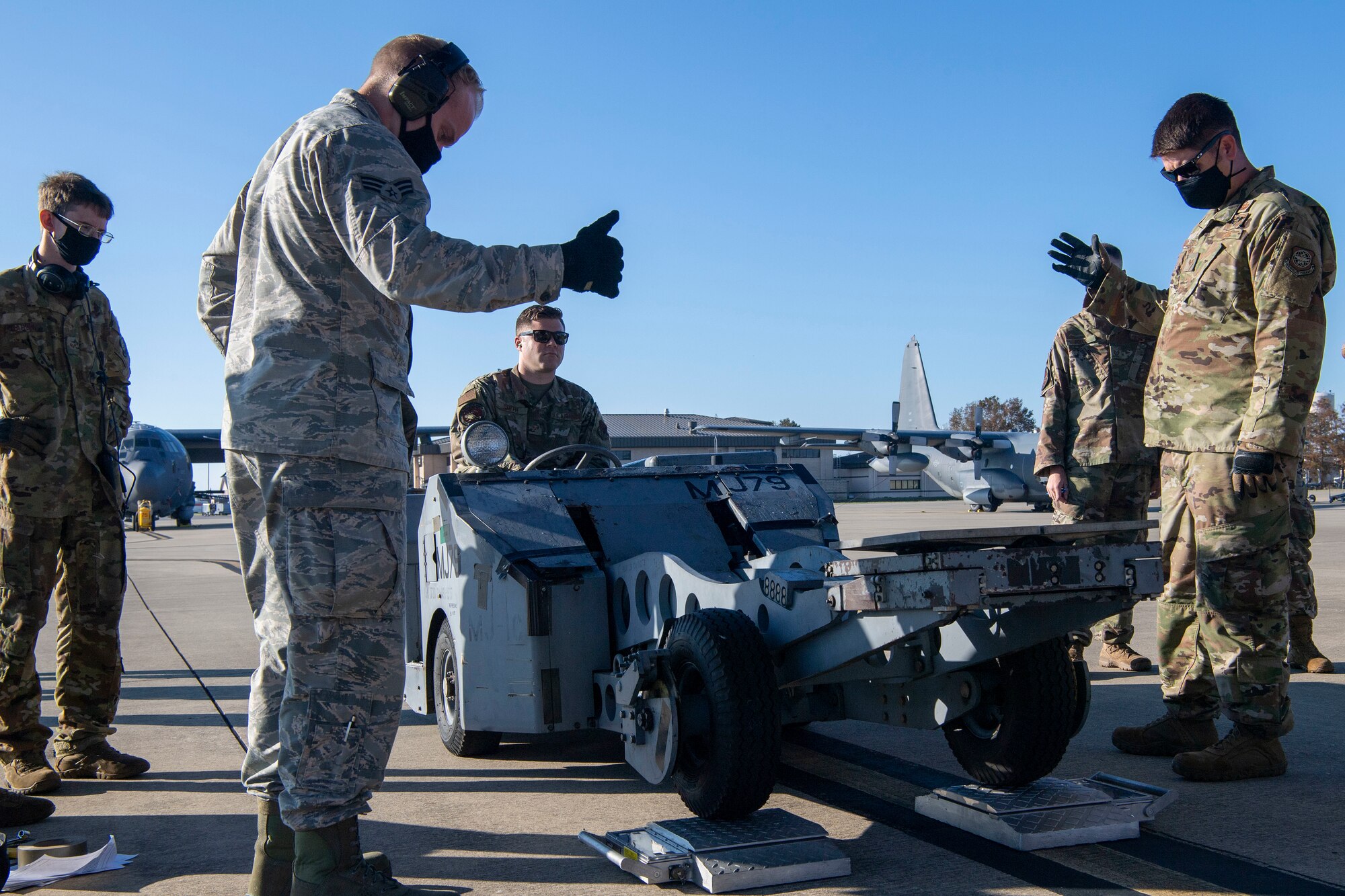 Airmen weigh a jammer before loading it onto a C-130J.