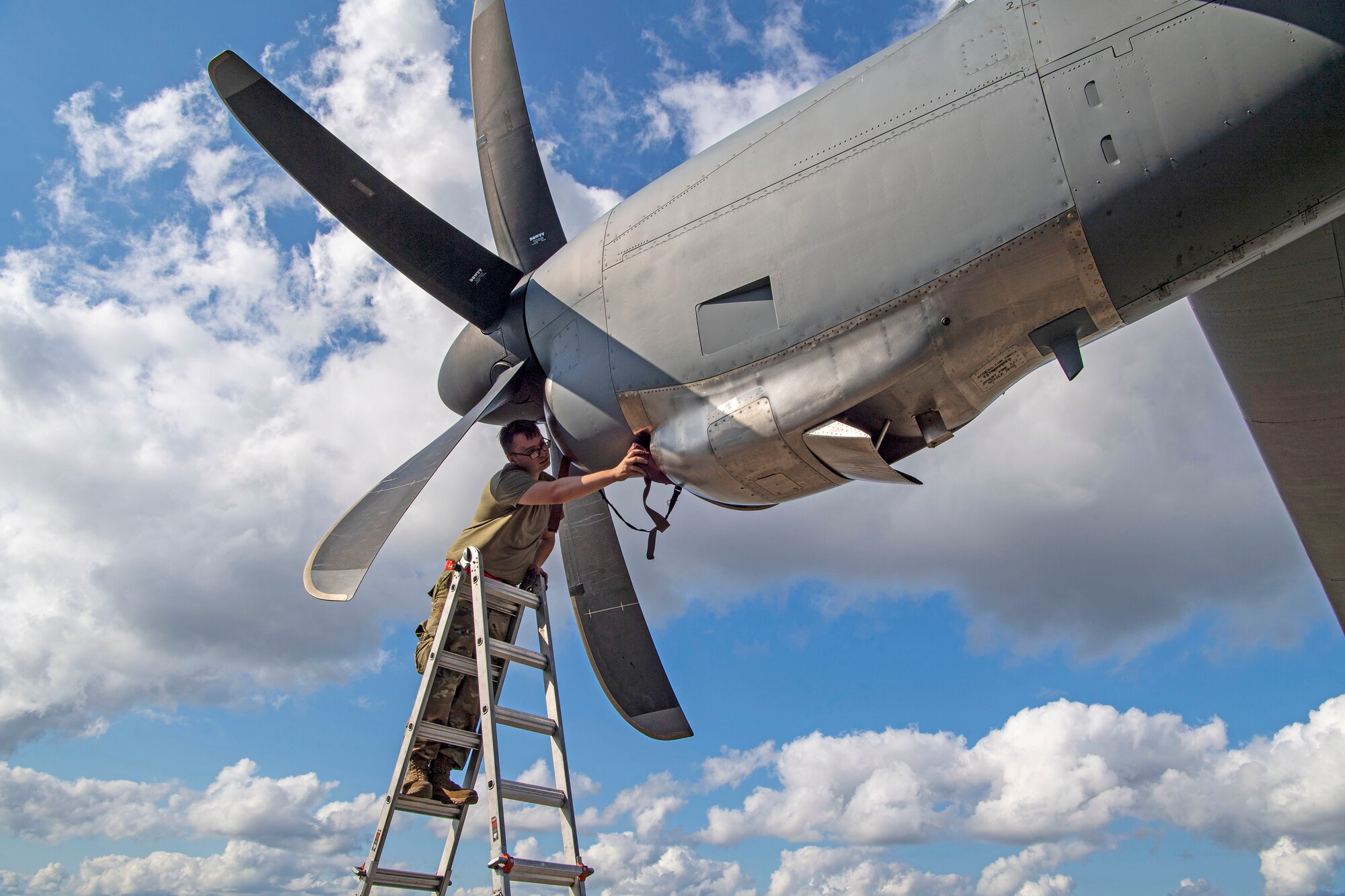 A maintenance Airman checks the props on a C-130J.
