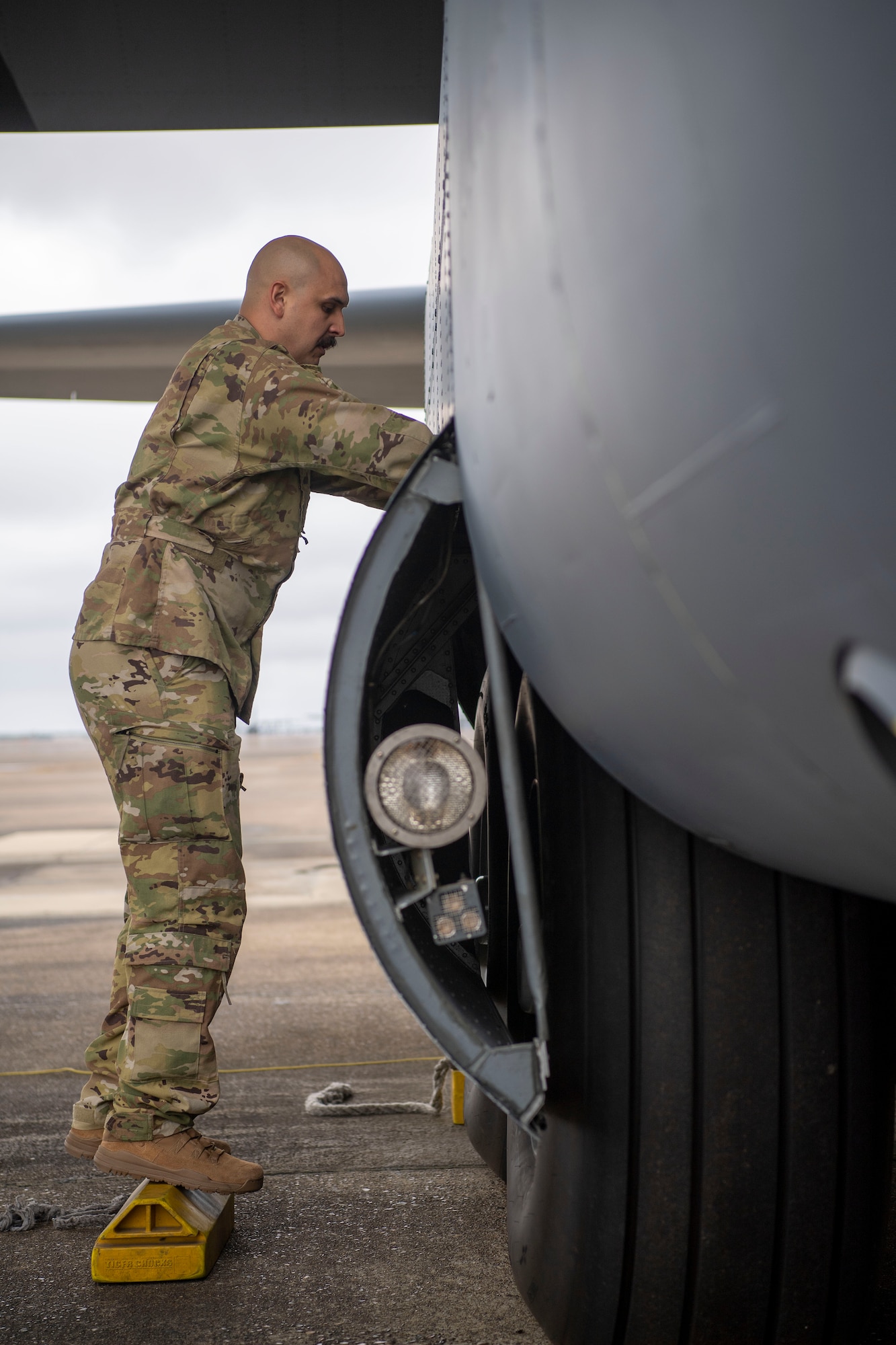 A loadmaster conducts a pre-flight check on a C-130J Super Hercules.