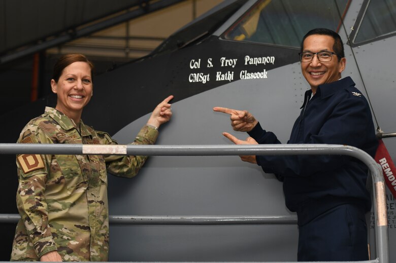U.S. Air Force Col. Troy Pananon, 100th Air Refueling Wing commander, and Chief Master Sgt. Kathi Glascock, 100th ARW command chief, unveil the new stencil on a KC-135 Stratotanker aircraft at Royal Air Force Mildenhall, England, Oct. 29, 2020. Normally, only the names of pilots and maintainers are stenciled on aircraft, making the addition of the command chief’s name unique. (U.S. Air Force photo by Staff Sgt. Anthony Hetlage)