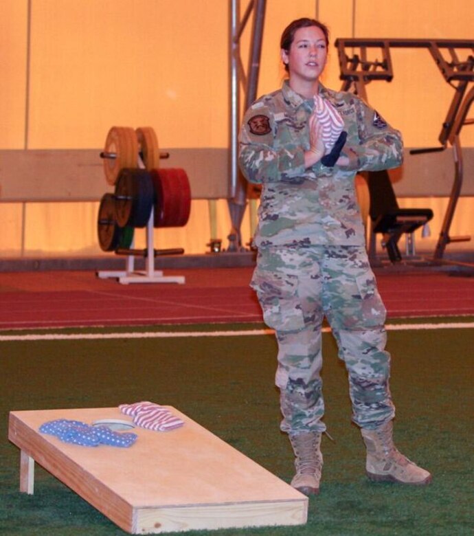 First Lt. Meghan Moore, 4th Space Operations Squadron executive officer, calculates the score while holding a pair of bean bags while calculating the score during an intramural cornhole contest at the Indoor Running Track at Schriever Air Force Base, Colorado on Oct. 27, 2020., Intramural sports typically available at this time of the year are canceled due to the ongoing coronavirus pandemic. The 50th Force Support Squadron filled the gap with a two-person intramural cornhole season, which takes place every Tuesday and Thursday. (U.S. Space Force photo by Marcus Hill)