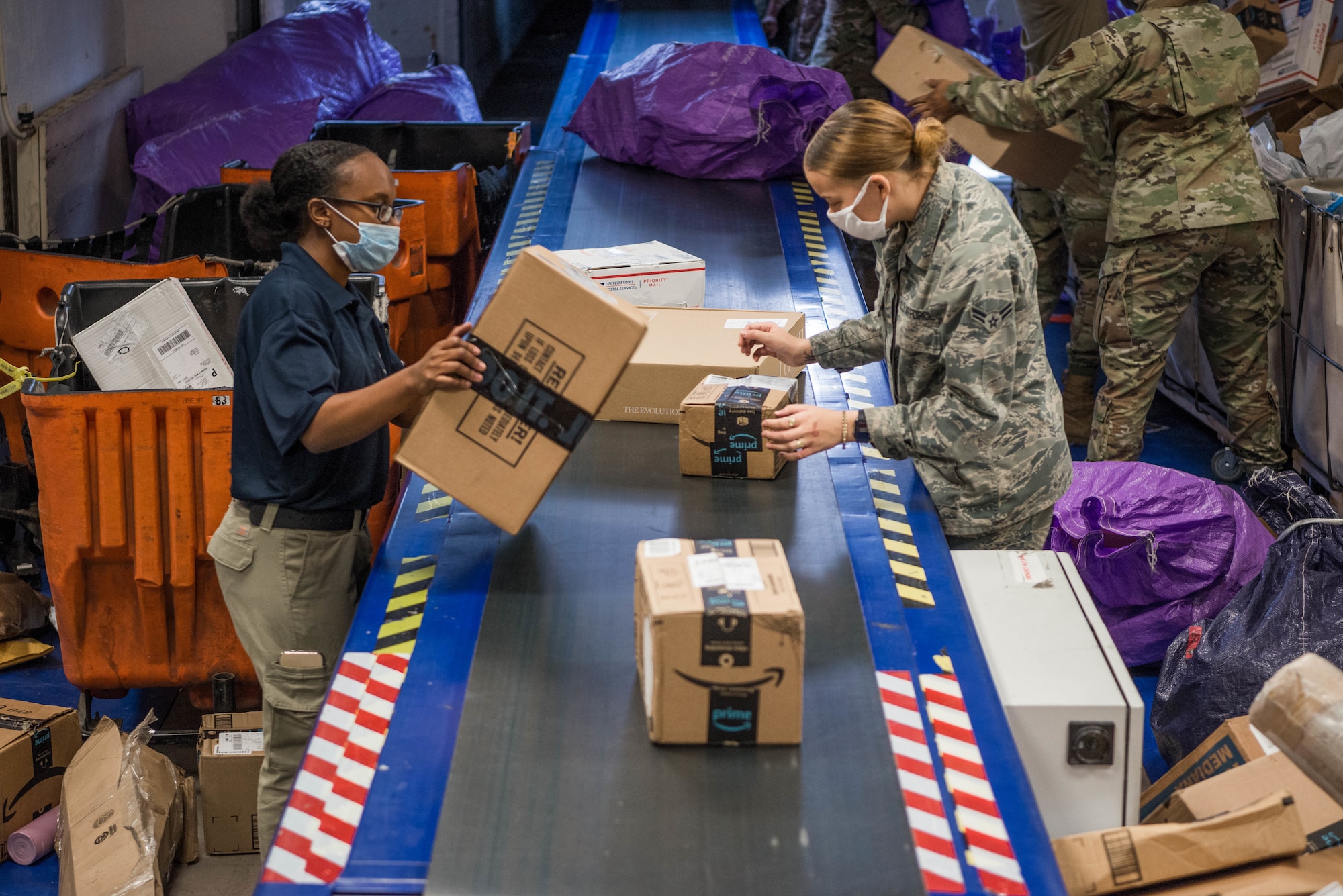 U.S. Air Force Airman 1st Class Kaliah Evans, left, and Airman 1st Class Malaysia Vance, right, 786th Force Support Squadron military postal clerks, process incoming packages at Ramstein Air Base, Germany, Oct. 28, 2020. Receiving the extensive amount of mail delivered daily is a team effort and requires assistance from the majority of Airmen in the post office. (U.S. Air Force photo by Senior Airman Noah Coger)