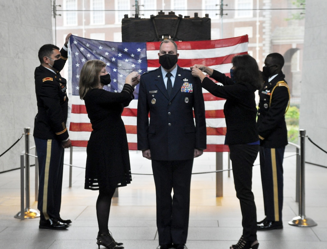 DLA Troop Support Clothing and Textiles Director Col. Justin Swartzmiller, center, is pinned to the rank of colonel by his sister Stacie, left, and wife Cecelia, right, during a promotion ceremony in his honor at the Liberty Bell Center in Philadelphia October 28, 2020. DLA Troop Support Commander Army Brig. Gen. Gavin Lawrence officiated the socially distanced ceremony.