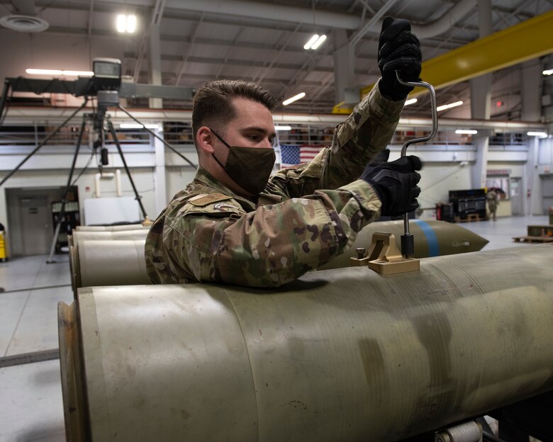 An Airman uses a speed handler to a shipping lug.