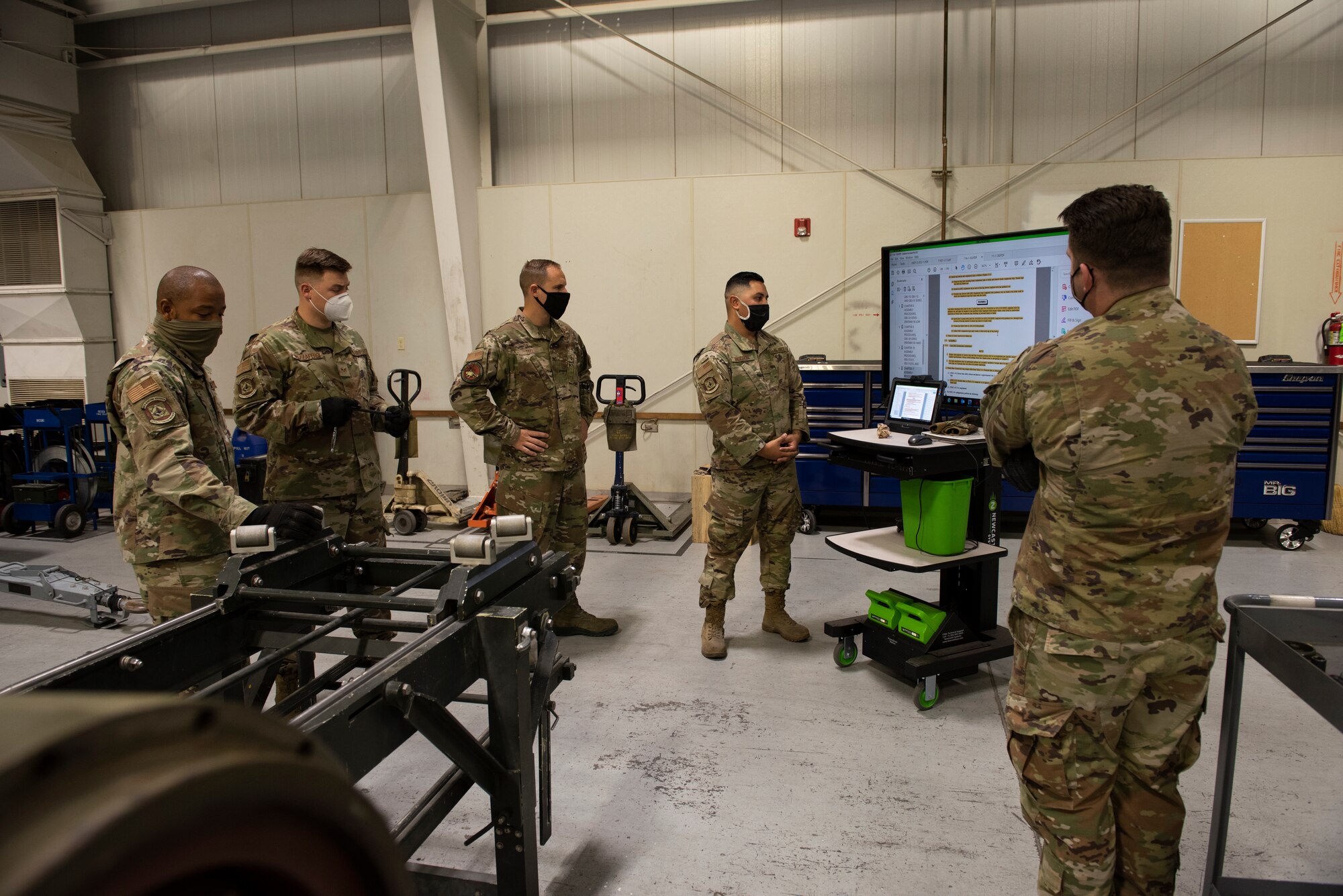 A group of Airmen are informed about munitions safety and assembly procedures.