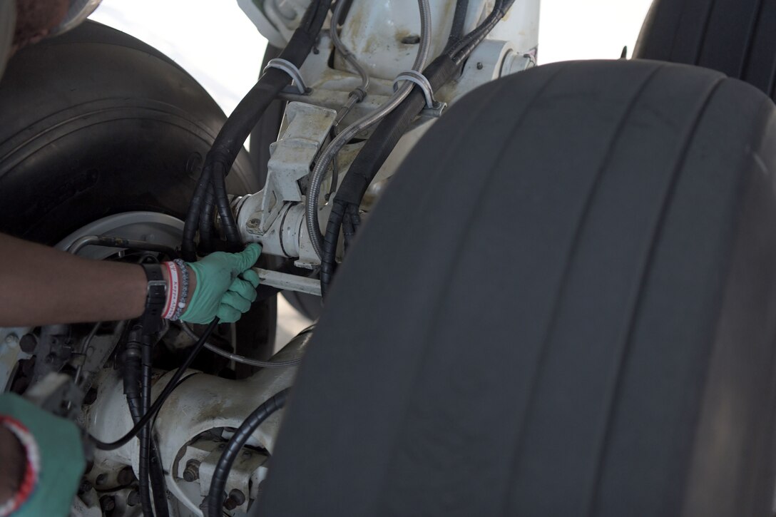 Staff Sgt. Dermayne Bullock, an E-8C joint surveillance target attack radar system crew chief with the 5th Expeditionary Airborne Command and Control Squadron, lubricates landing gear, Sept. 24, 2020, at Kadena Air Base, Japan. The Air National Guard and active duty members from Robins Air Force Base, Georgia, are on three-month rotations to work with the 5EACCS on KAB to promote total force integration and joint interoperability. (U.S. Air Force photo by Airman 1st Class Rebeckah Medeiros)