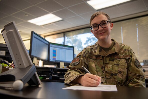 A woman sits at a desk.