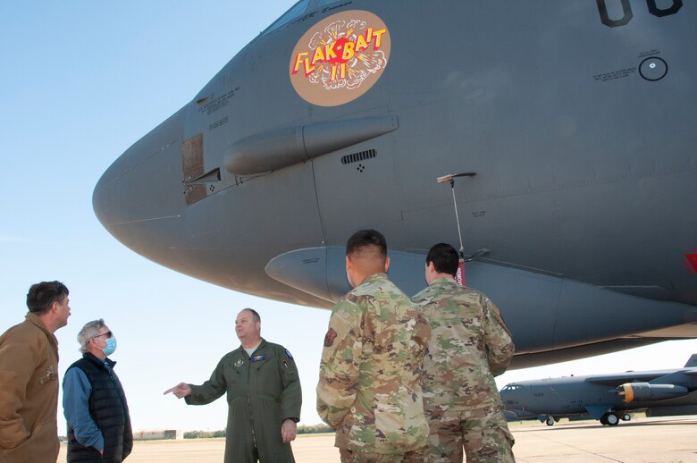 People stand and talk in front of a B-52.