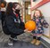 Staff Sgt. Megan Aycock, Colorado Springs Regional Command Post emergency actions controller, left, hands a pumpkin to her daughter Mabry, 1, as they prepare to leave the Child Development Center at Schriever Air Force Base Oct. 23, 2020. Parents picked up pumpkins to decorate for fun or to enter into the 50th Force Support Squadron’s pumpkin carving contest. (U.S. Space Force photo by Marcus Hill)