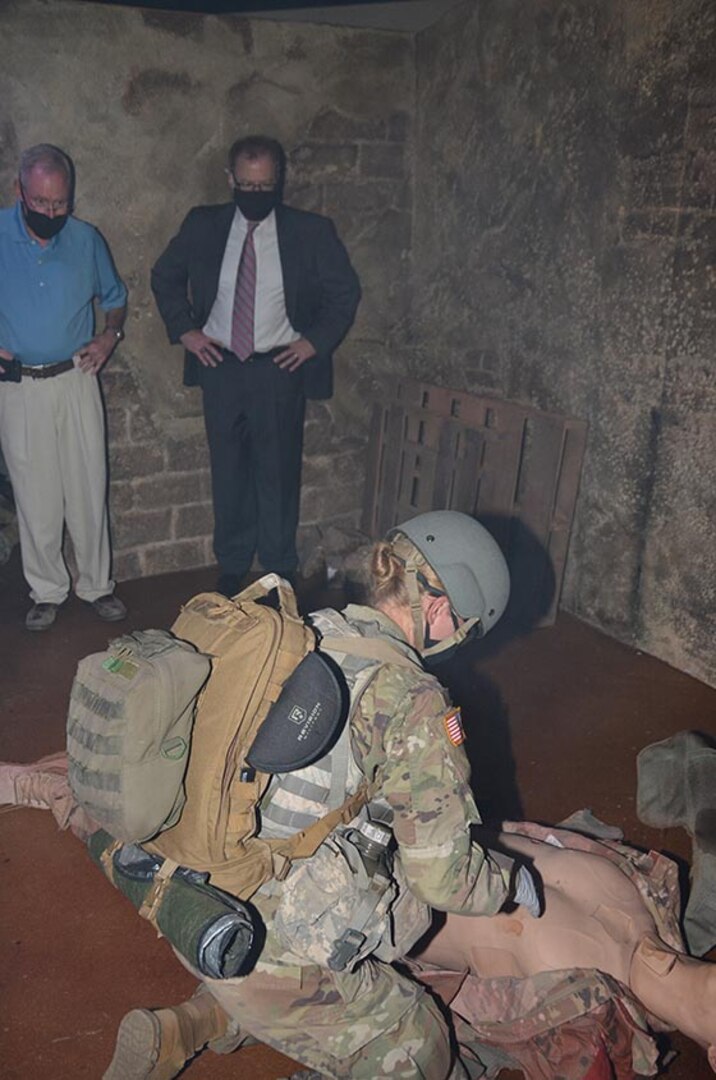 Secretary of Defense for Health Affairs, observes a Combat Medic Specialist Program student as she assesses and treats a "casualty" in the Combat Trauma Patient Simulator