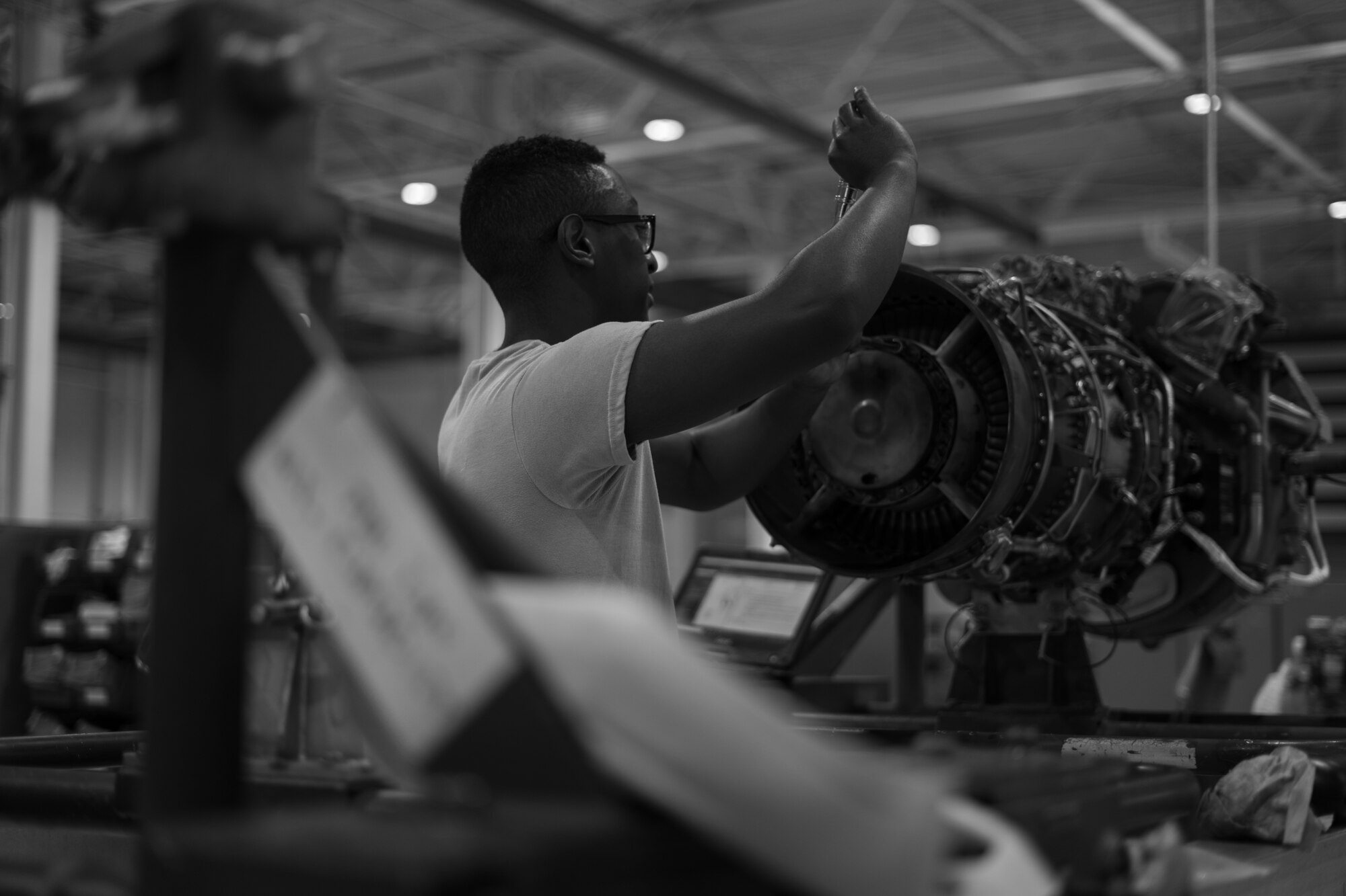 An Airman works on an aircraft engine